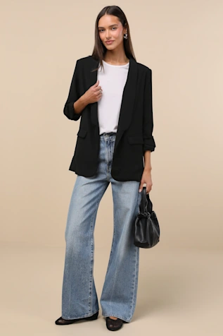 A woman in a sleeveless cropped blazer made of pink tweed fabric.