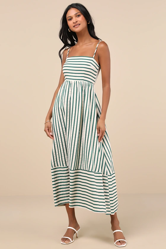 A woman in a green and cream striped cutout midi dress.